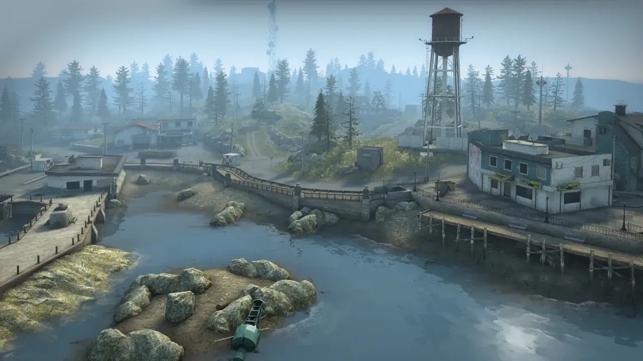 Mglisty krajobraz z budynkami, wieżą ciśnień i lasem. To miejsce z CS GO Danger Zone, gdzie każdy ruch może być ostatnim.