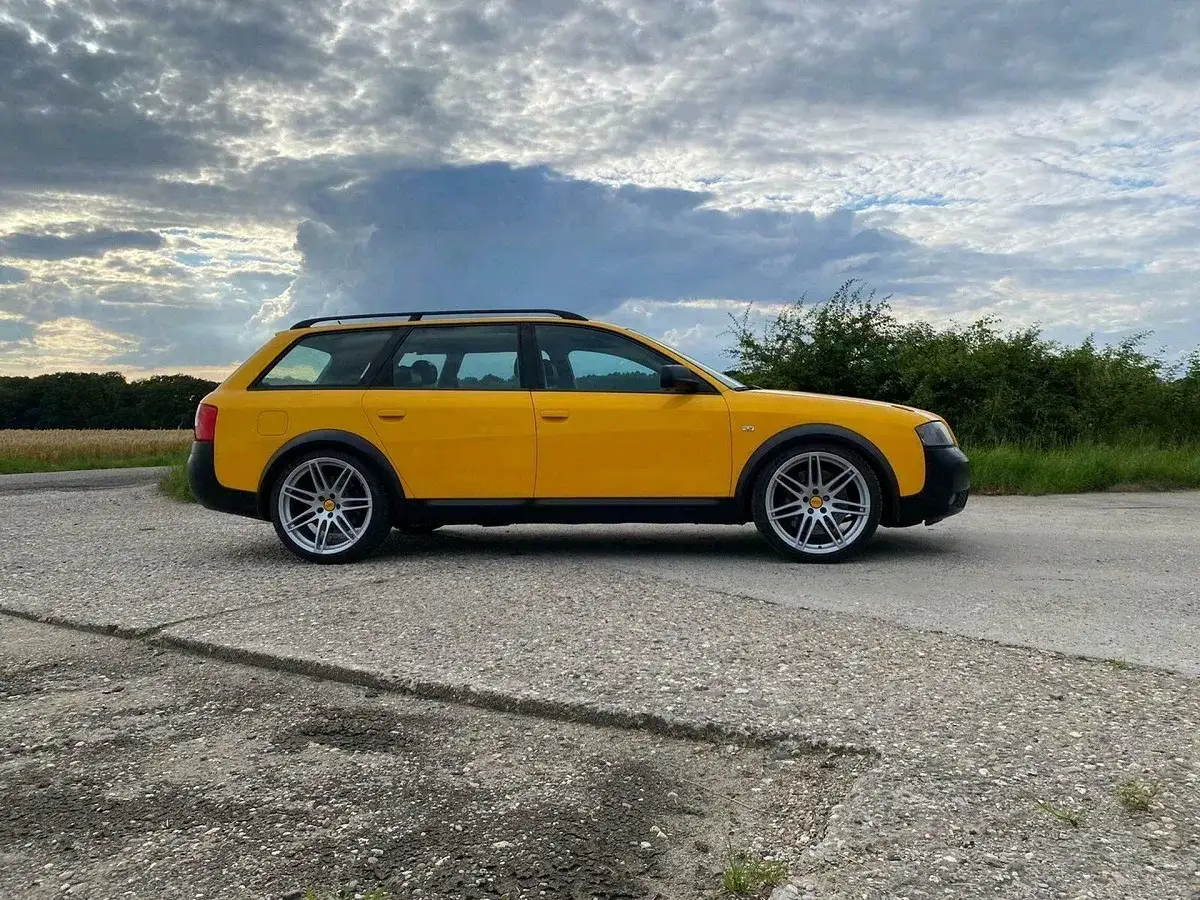 Żółte Audi RS6 C5 Allroad na tle burzowego nieba, gotowe na przygodę.