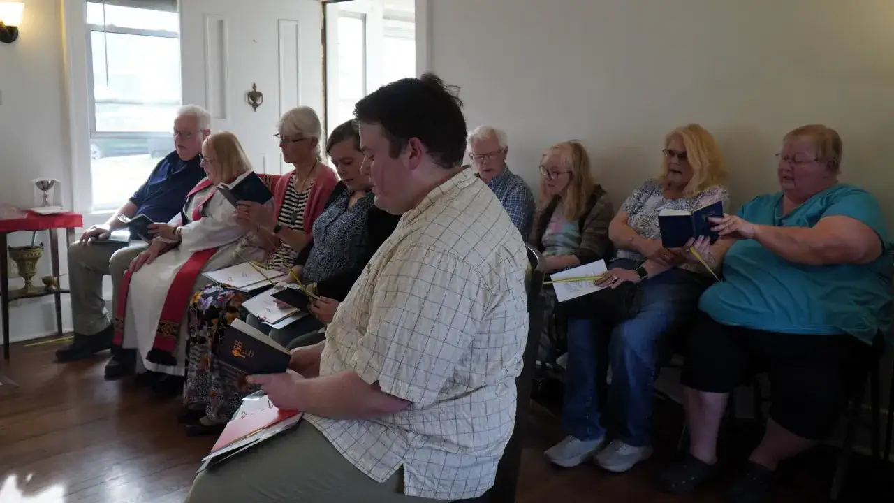 A group gathers for matins, reading from prayer books.