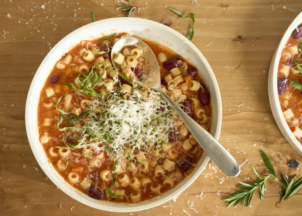 Aromaticzna zupa neapolitańska z makaronem ditalini, fasolą i pomidorami, posypana parmezanem i świeżą bazylią.