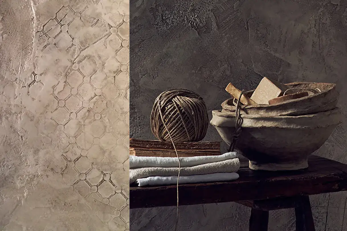 Pareti con pittura a calce decorata con motivo a rombi e oggetti rustici: gomitolo di spago, libri antichi, asciugamani e ciotole di carta.