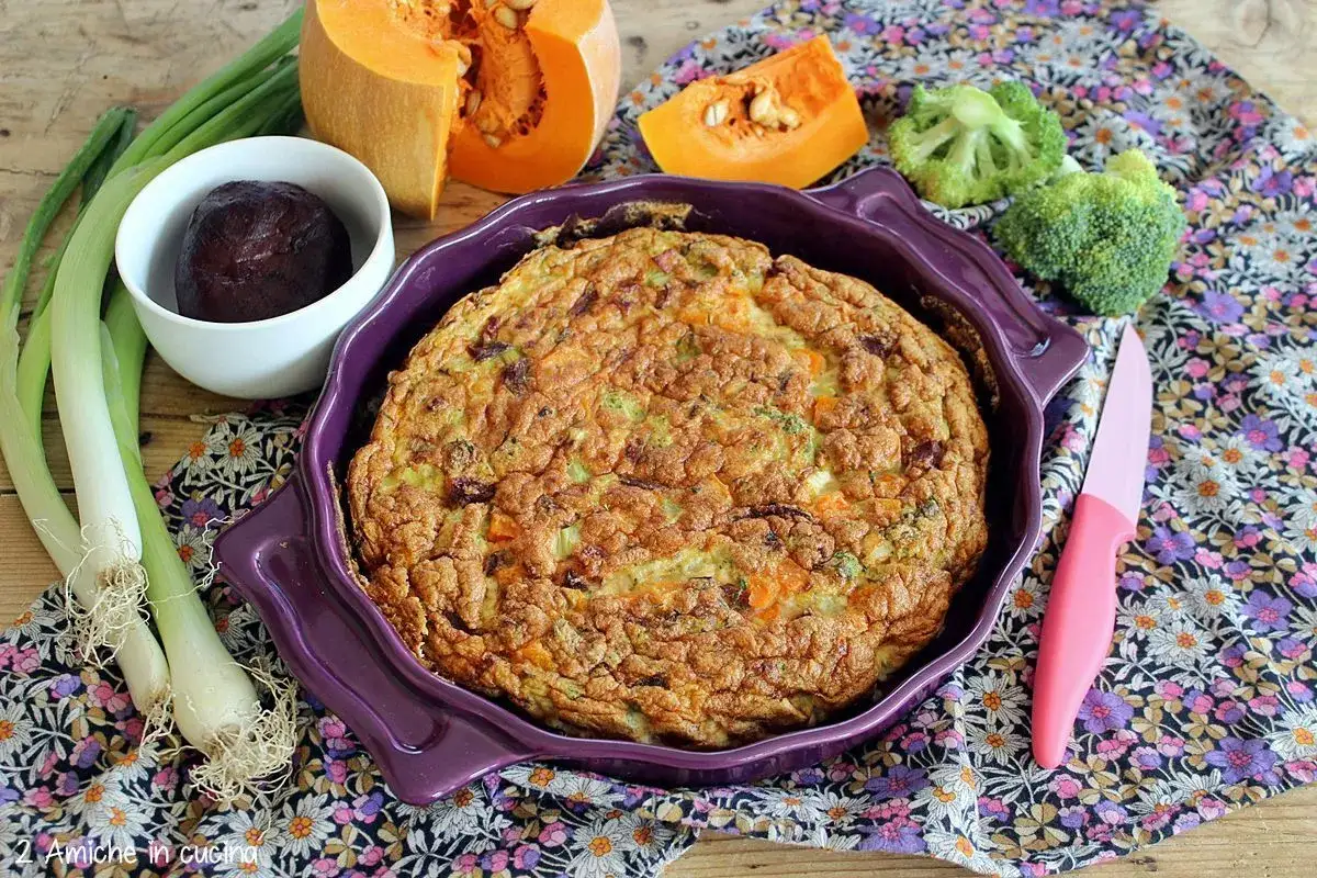 Frittata di albumi dorata e soffice, con verdure colorate, pronta per essere gustata. Accanto, zucca, broccoli, cipollotti e barbabietola.