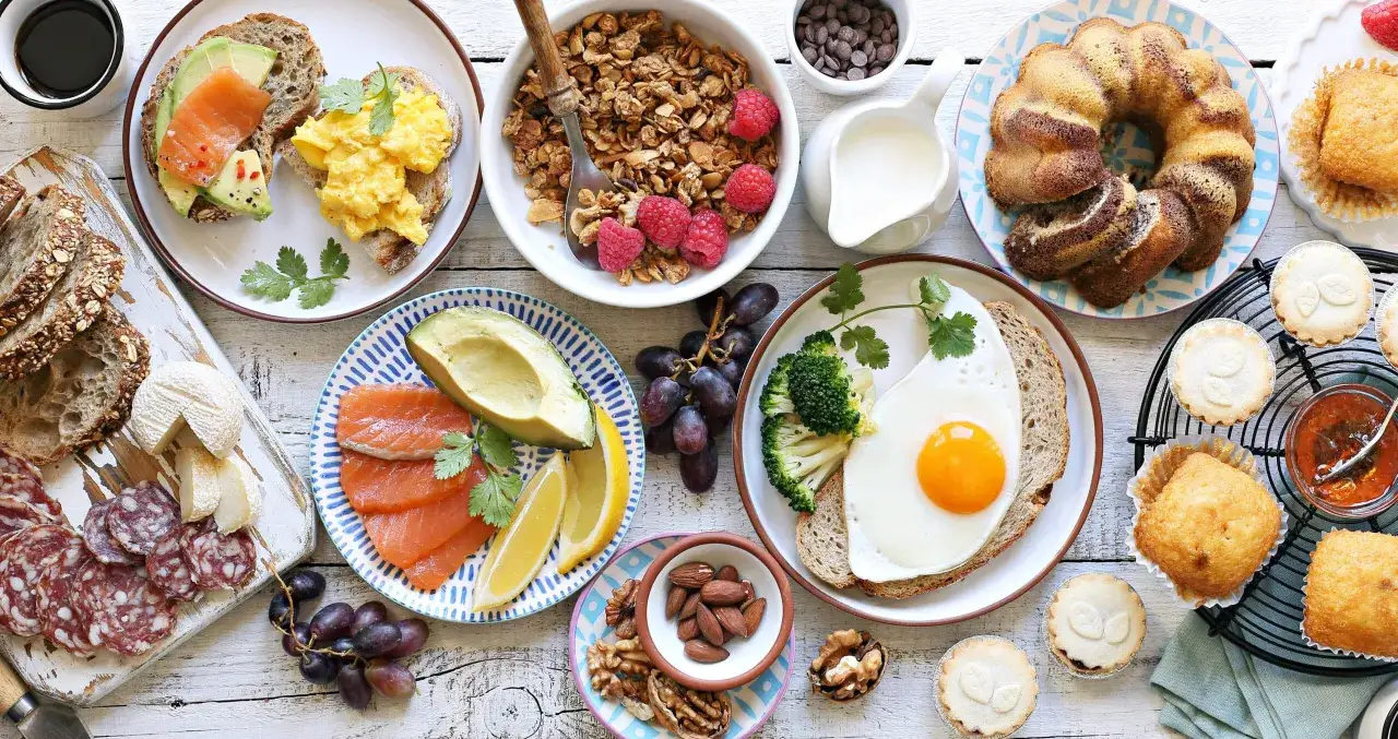 Leckeres Fingerfood f&uuml;r den Osterbrunch: R&uuml;hrei, Lachs, Avocado, Kuchen, Muffins und N&uuml;sse.