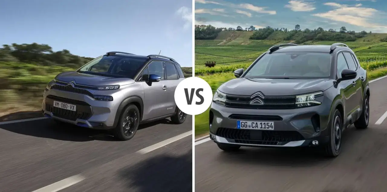 Dwa modele Citroen Aircross, jeden srebrny, drugi ciemnoszary, jadące po drodze na tle krajobrazu.