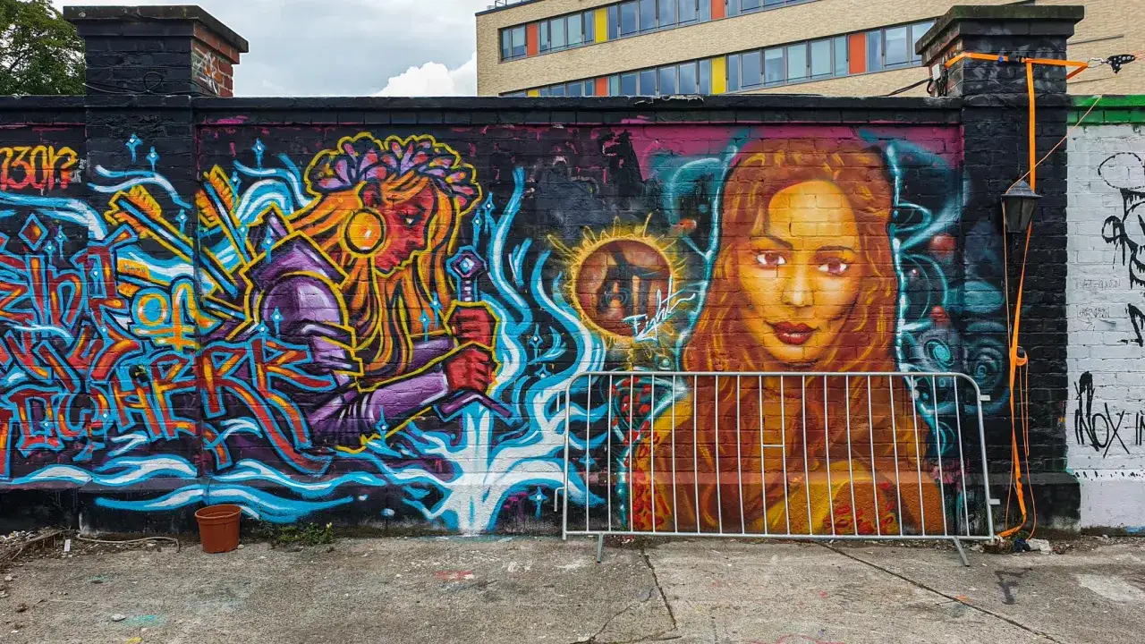 Farbenfrohe Street Art in M&uuml;nchen: Eine Kriegerin mit Schwert und ein Portr&auml;t einer Frau zieren die Mauer.
