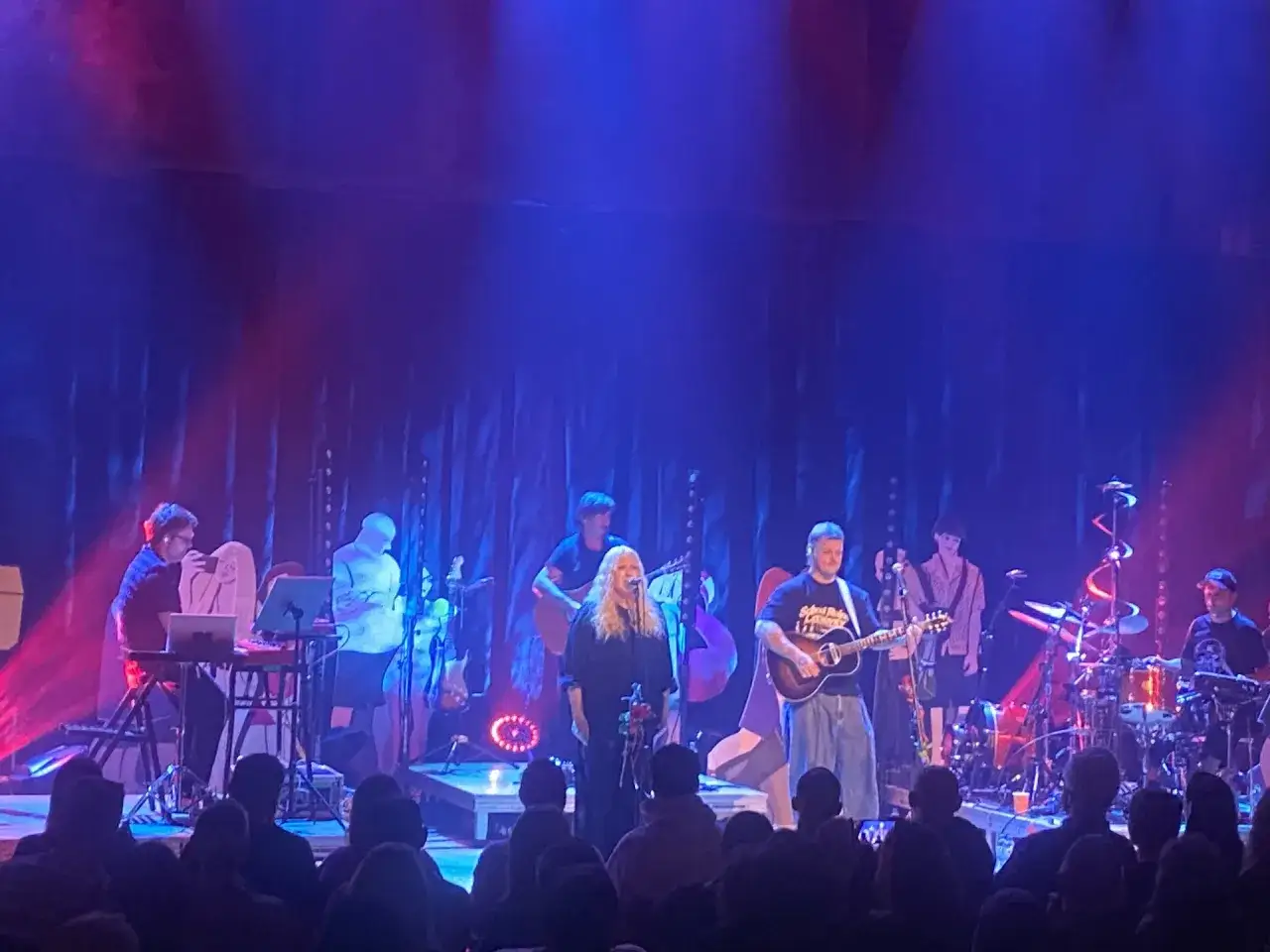 Nosowska i Błażej Król na scenie, w tle zespół i instrumenty. Koncert pełen energii, jak neodym przyciąga uwagę.
