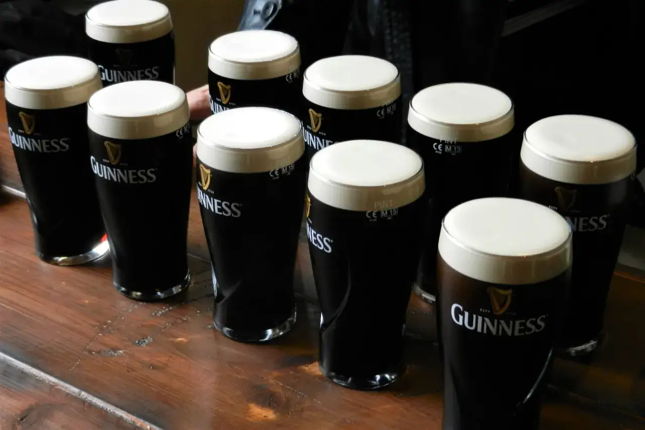 Szklanki z Guinnessem na drewnianym blacie. Ile procent ma Guinness? To zależy od rodzaju, ale klasyczny ma ok. 4.2%.