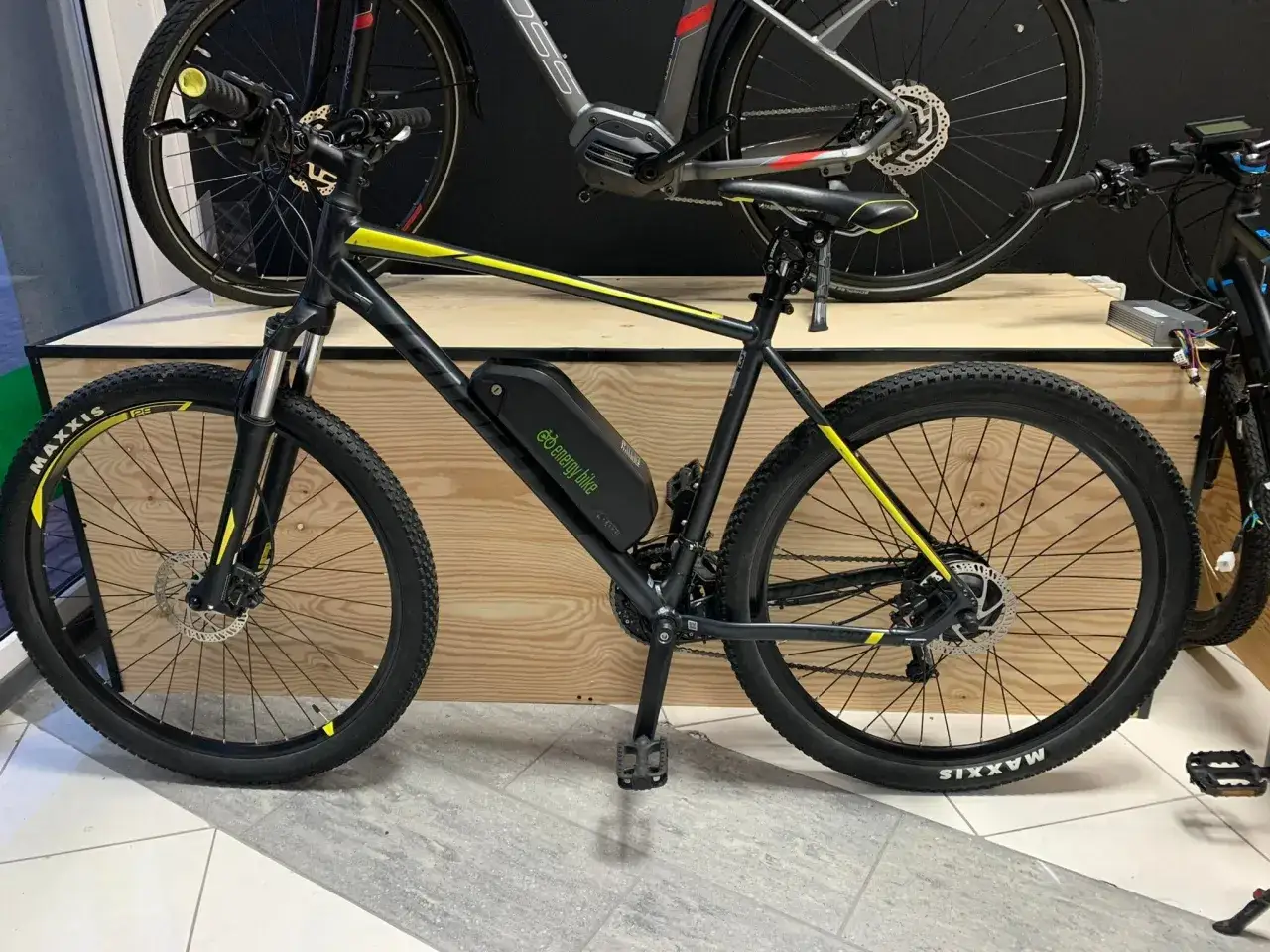 Czarny rower z żółtymi akcentami, wyposażony w koło elektryczne do roweru 26 cali. Bateria zamontowana na ramie.