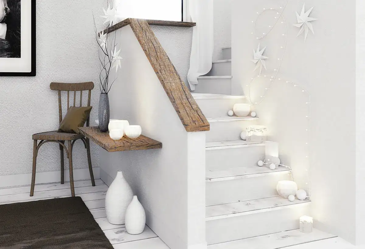 Un miroir dans une montée d'escalier, décorée de guirlandes lumineuses et d'étoiles en papier, crée une ambiance chaleureuse et festive.