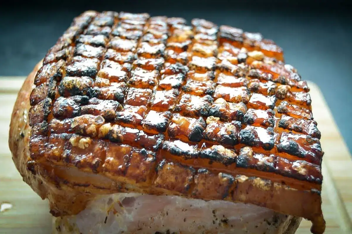 Ein knuspriger Krustenbraten aus dem Backofen, die Schwarte ist perfekt aufgegangen und glänzt.