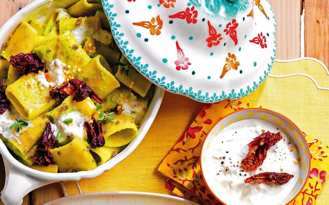 Paccheri verdi con crema di patate, pomodori secchi e ricotta. Un piatto che celebra le ricette con patate, fresco e saporito.