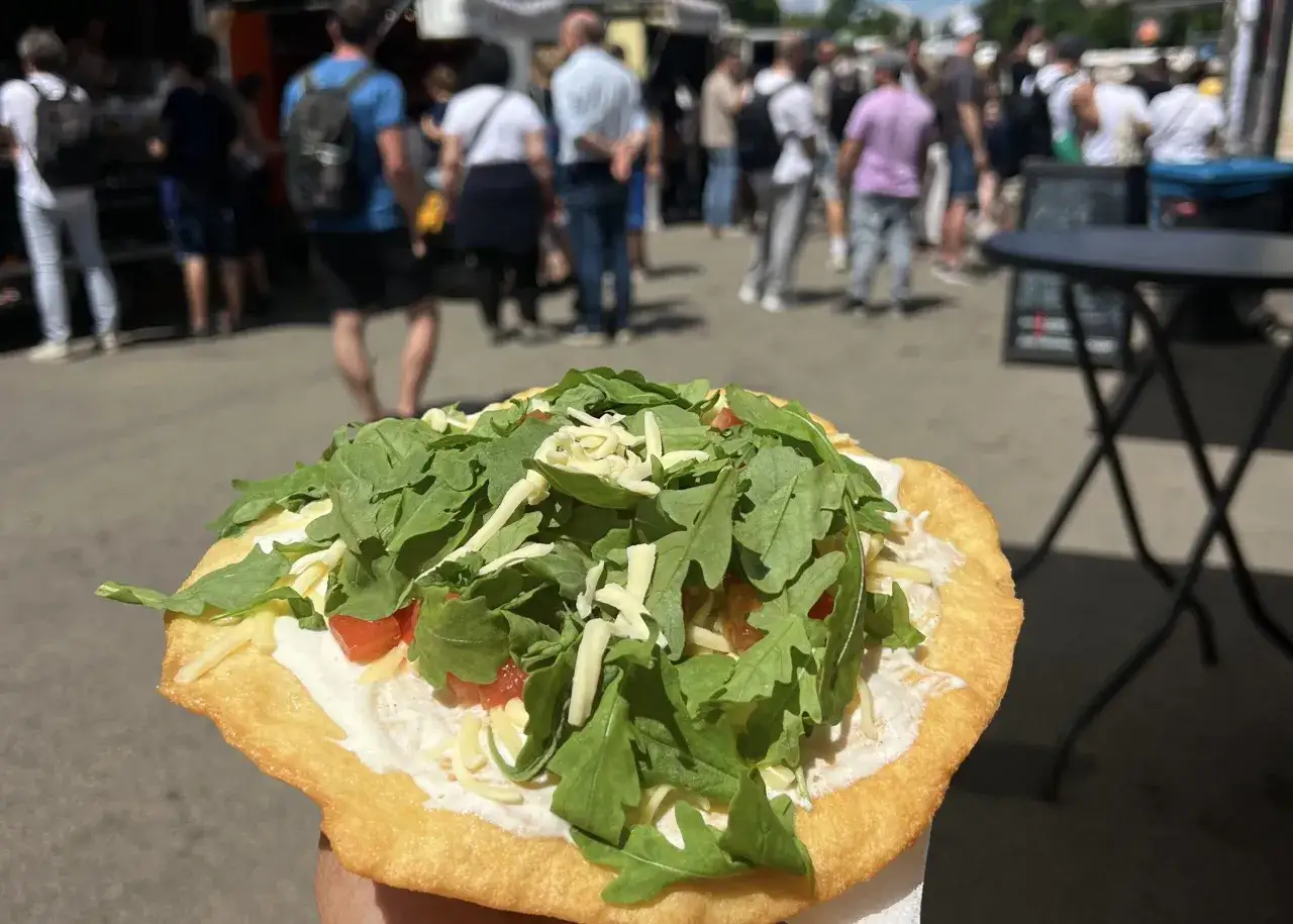 En frasig lángos med gräddfil, ruccola och ost. En perfekt matbit från en matmarknad, kanske i Berlin?