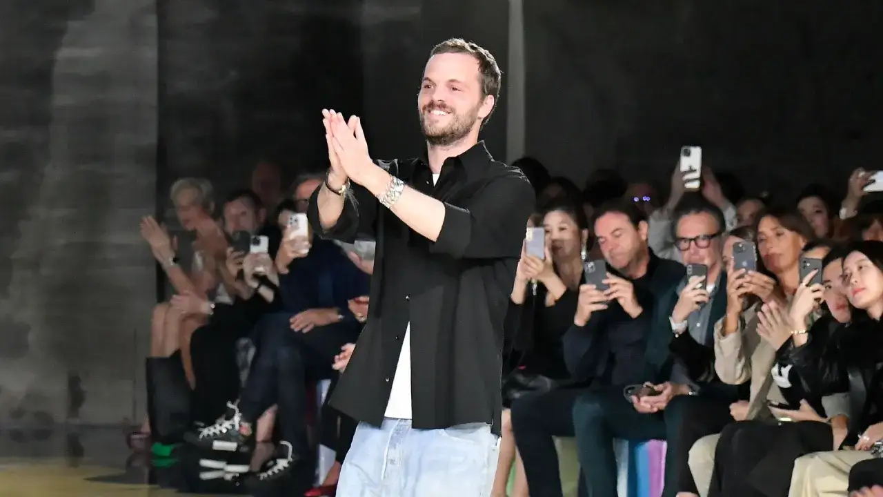 Matthieu Blazy, sonriendo y aplaudiendo, recibe ovación en desfile.