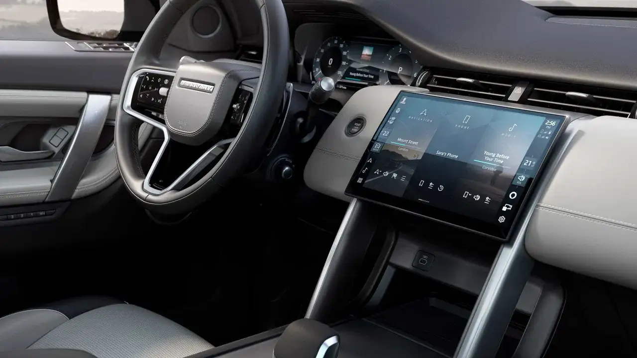 Wnętrze Land Rover Discovery z ekranem dotykowym, kierownicą i siedzeniem.