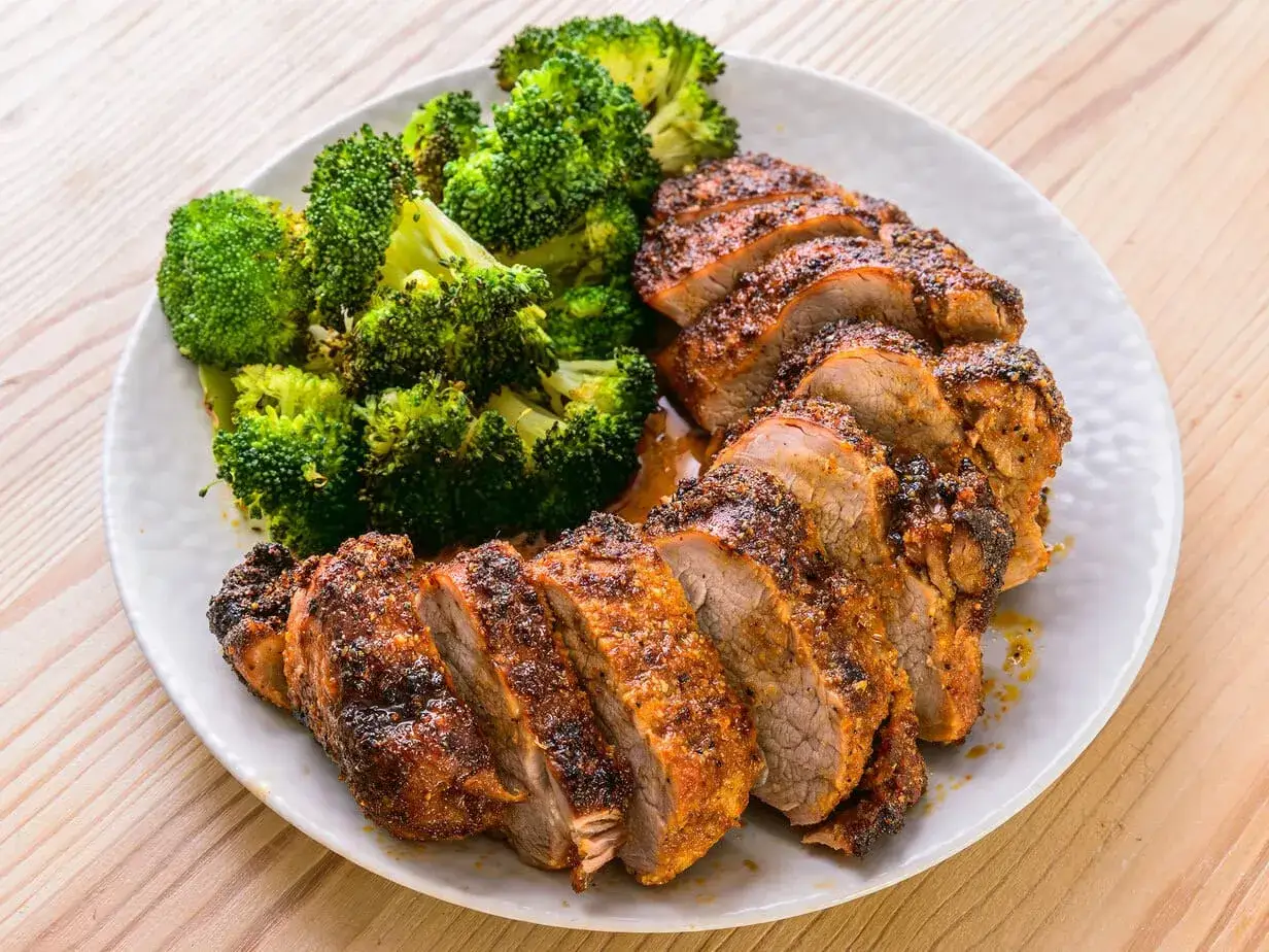 Filet mignon air fryer, tranché et servi avec du brocoli rôti. Un repas sain et savoureux.