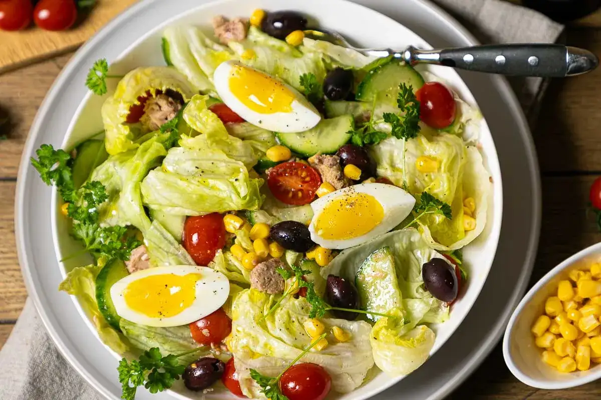 Frischer Salat mit knackigem Eisbergsalat, Tomaten, Gurken, Mais, Oliven, Ei und Thunfisch &ndash; ein weltbester Thunfischsalat!