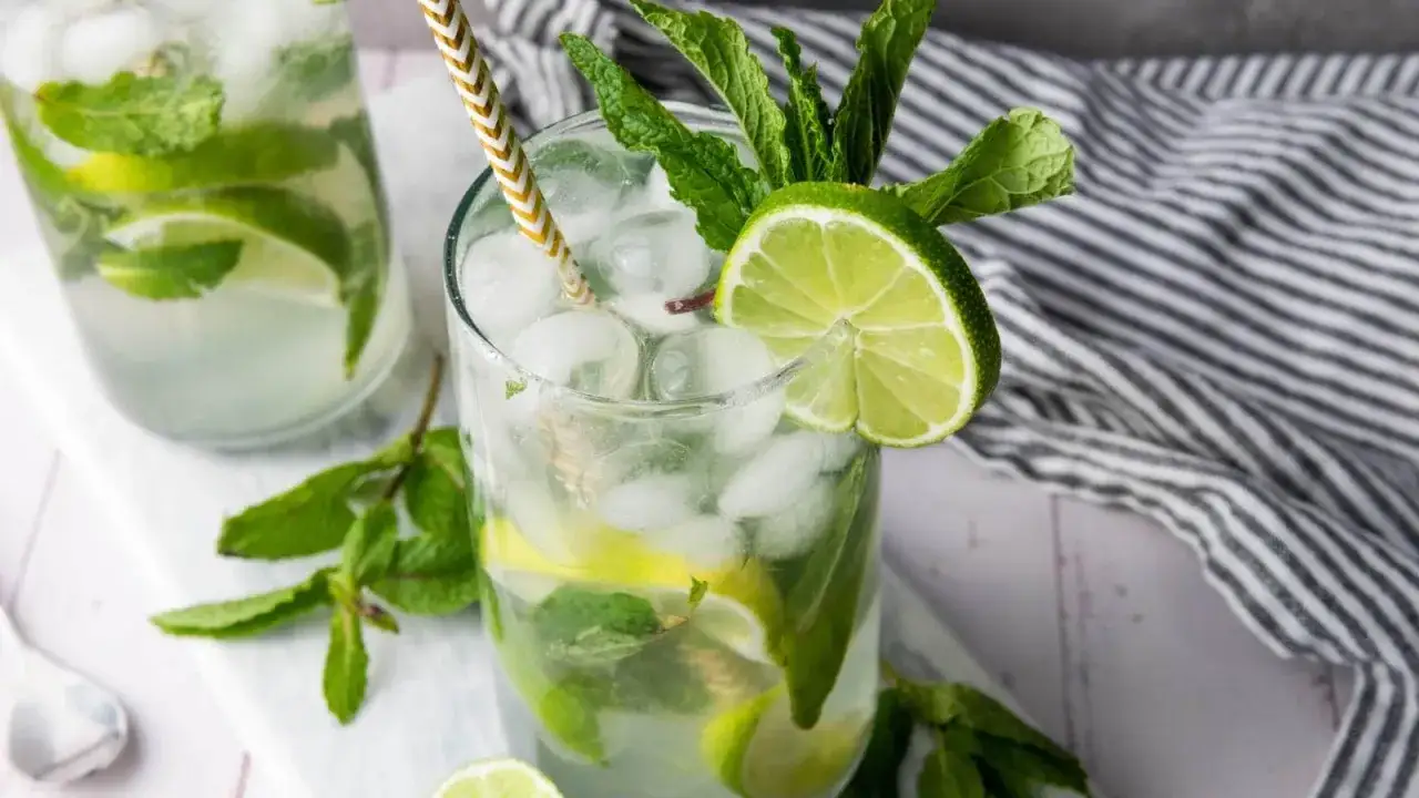 Un délicieux mocktail mojito rafraîchissant, garni de menthe fraîche et de rondelles de citron vert, prêt à être dégusté.