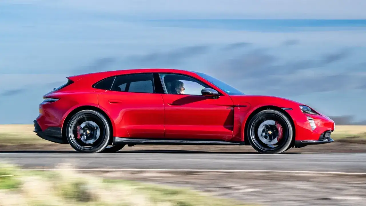 Roter Porsche Taycan Cross Turismo fährt auf einer Straße. Die technischen Daten dieses Elektroautos sind beeindruckend.