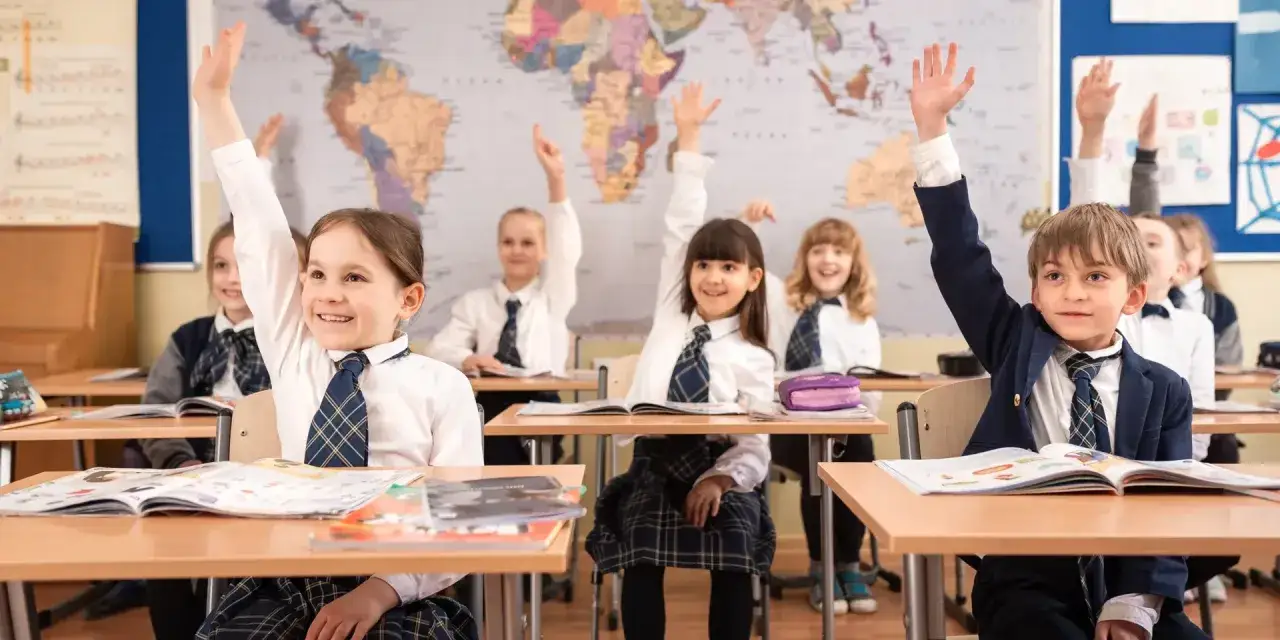 Uczniowie z podniesionymi rękami, ciekawi świata na mapie. Zastanawiają się, od której klasy drugi język obcy.