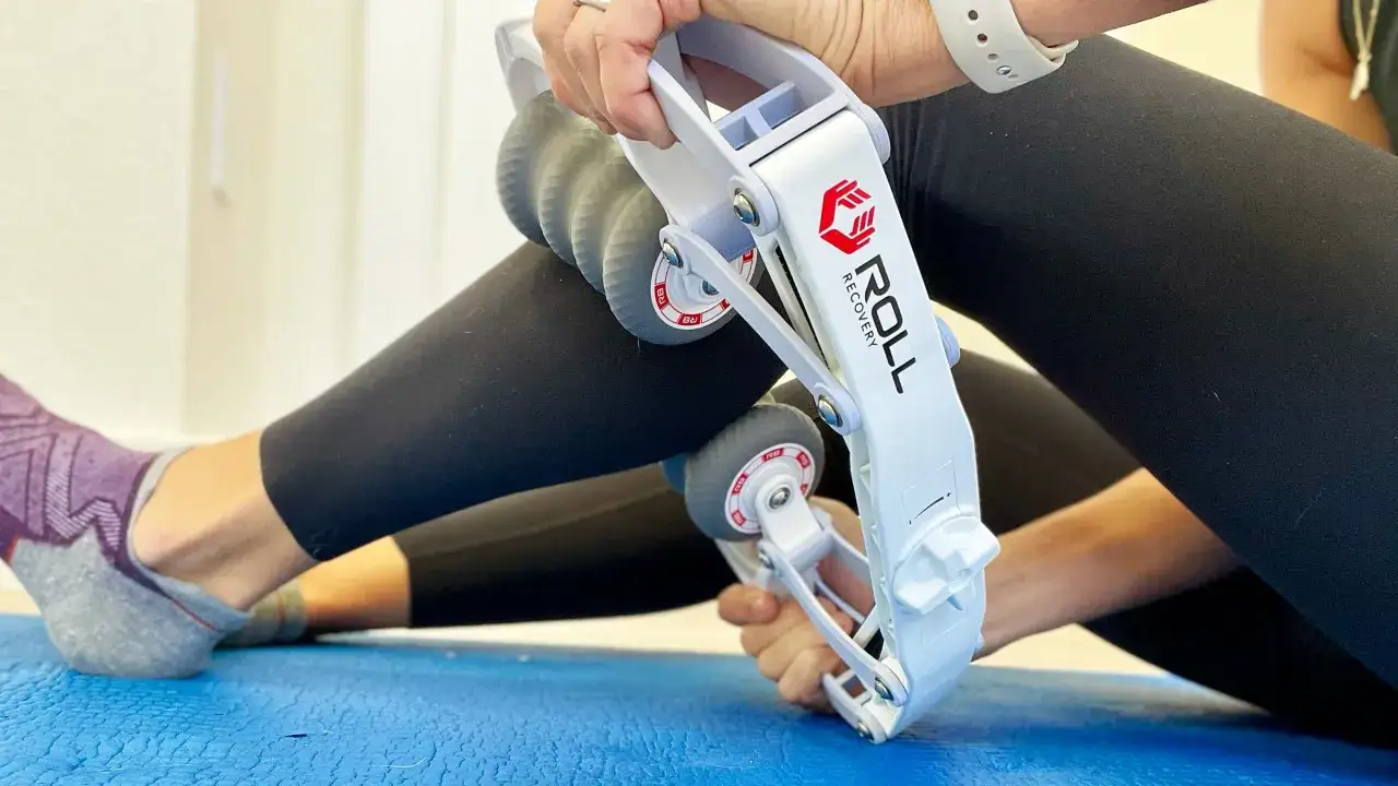 Une personne utilise un rouleau pour travailler les fascias de sa jambe, am&eacute;liorant ainsi sa r&eacute;cup&eacute;ration musculaire.