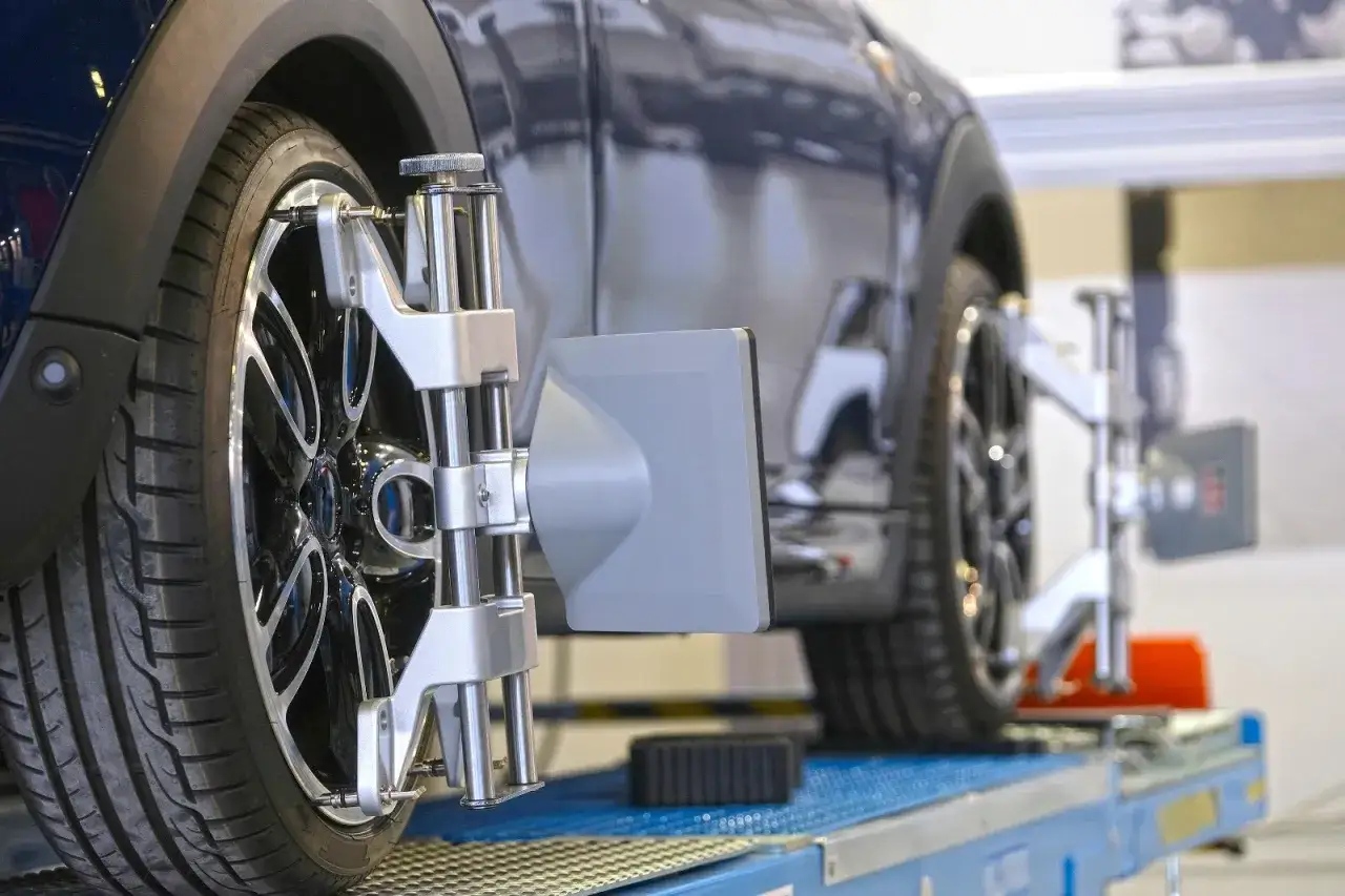 Messung der Achsgeometrie: So verstellt sich die Spur beim Auto. Präzisionsmessgeräte an den Rädern eines dunklen Autos.