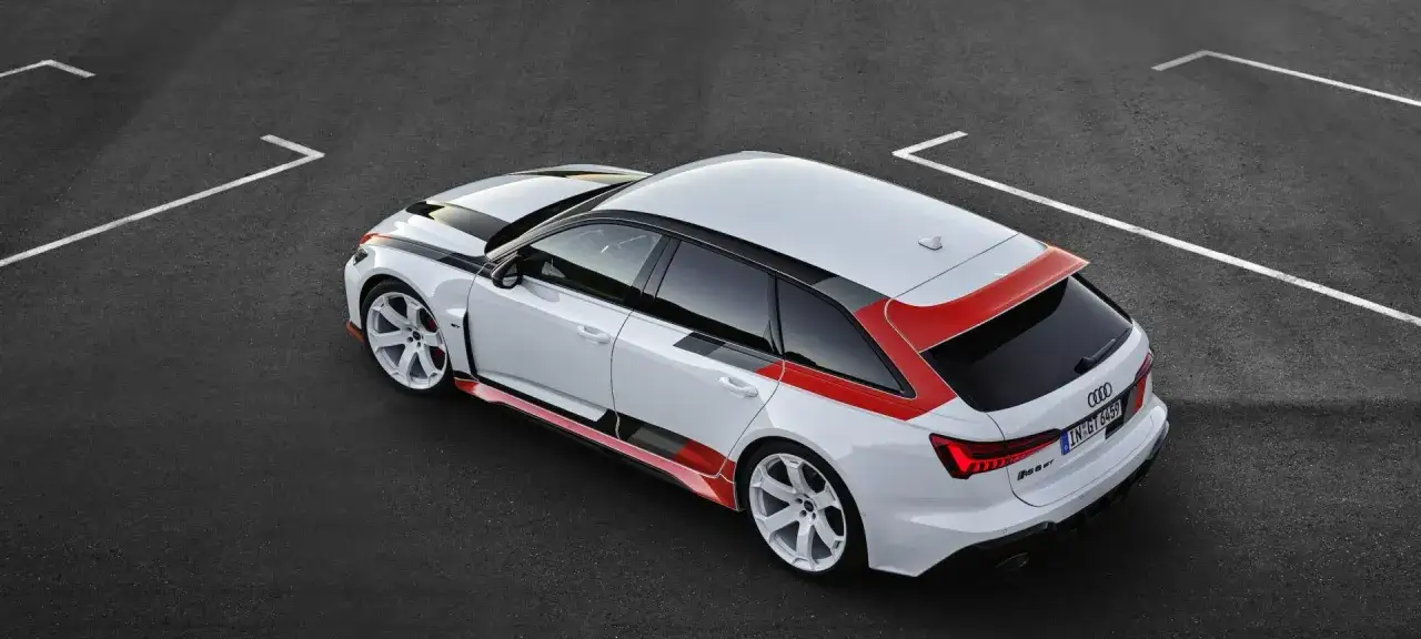 Białe Audi RS6 GT z czerwono-czarnymi akcentami na torze wyścigowym.