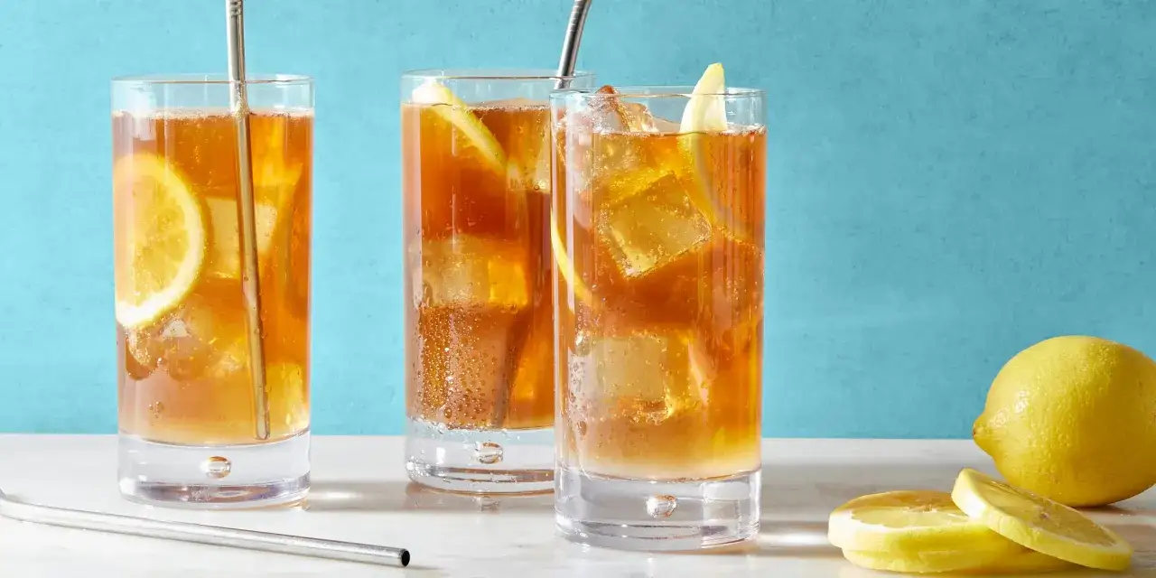 Trzy orzeźwiające drinki Long Island Iced Tea z cytryną i lodem, gotowe do podania.