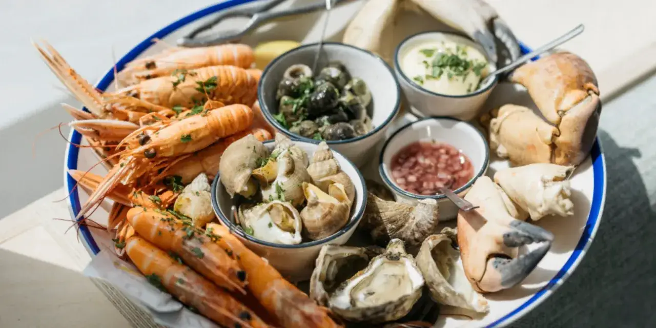 Plateau de fruits de mer avec langoustines, bulots, crevettes, huîtres et pinces de crabe. Un délice des spécialités Finistère.