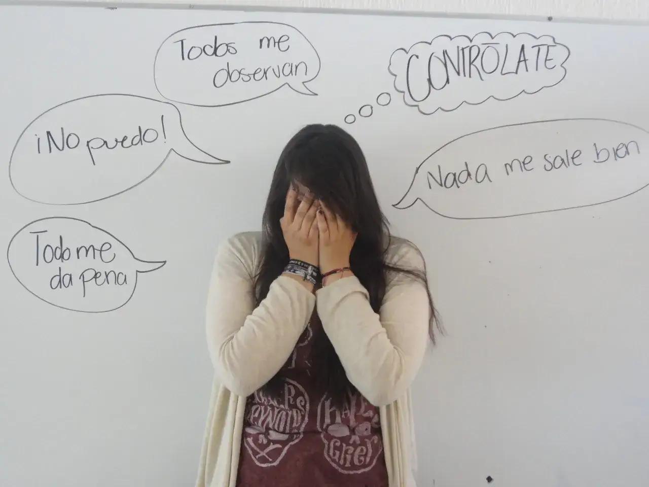 Una joven se tapa la cara, rodeada de bocadillos con frases como 