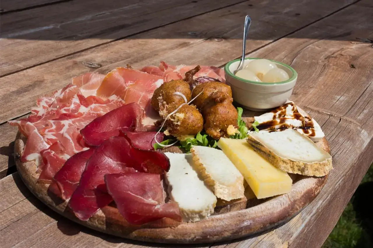 Tagliere con salumi, formaggi, frittelle e cipolline, un assaggio dei piatti tipici Valtellina.
