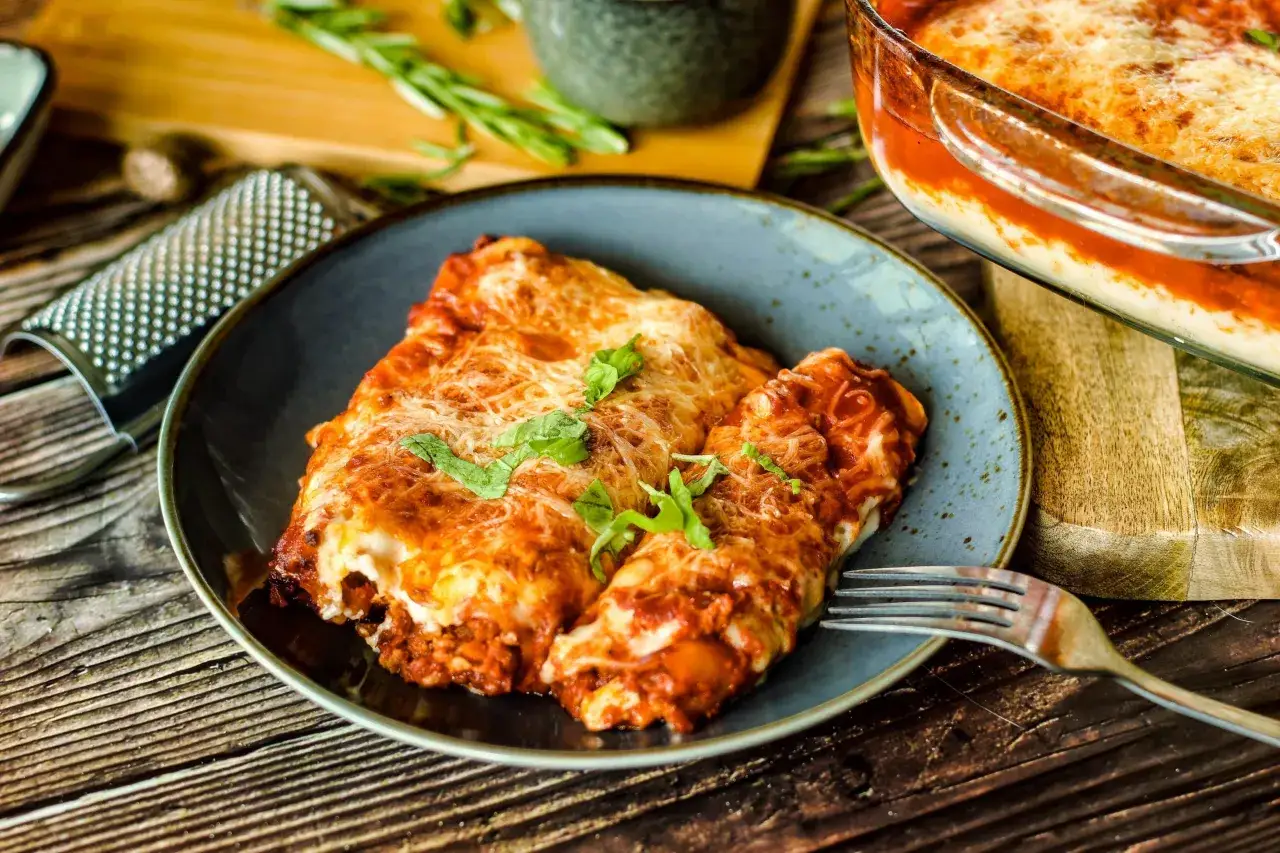 Ein Teller mit leckeren Cannelloni, überbacken mit Käse und Tomatensauce. Ein köstliches Cannelloni Rezept, das zum Nachkochen einlädt.