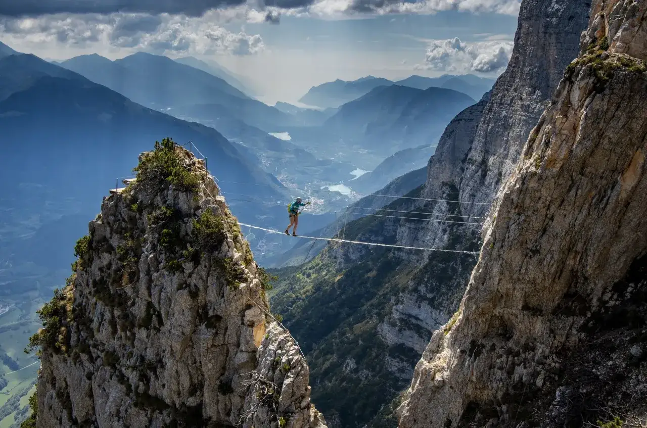 Odwaga na via ferrata polska! Osoba balansuje na linie między skalnymi szczytami, podziwiając zapierającą dech w piersiach górską panoramę.