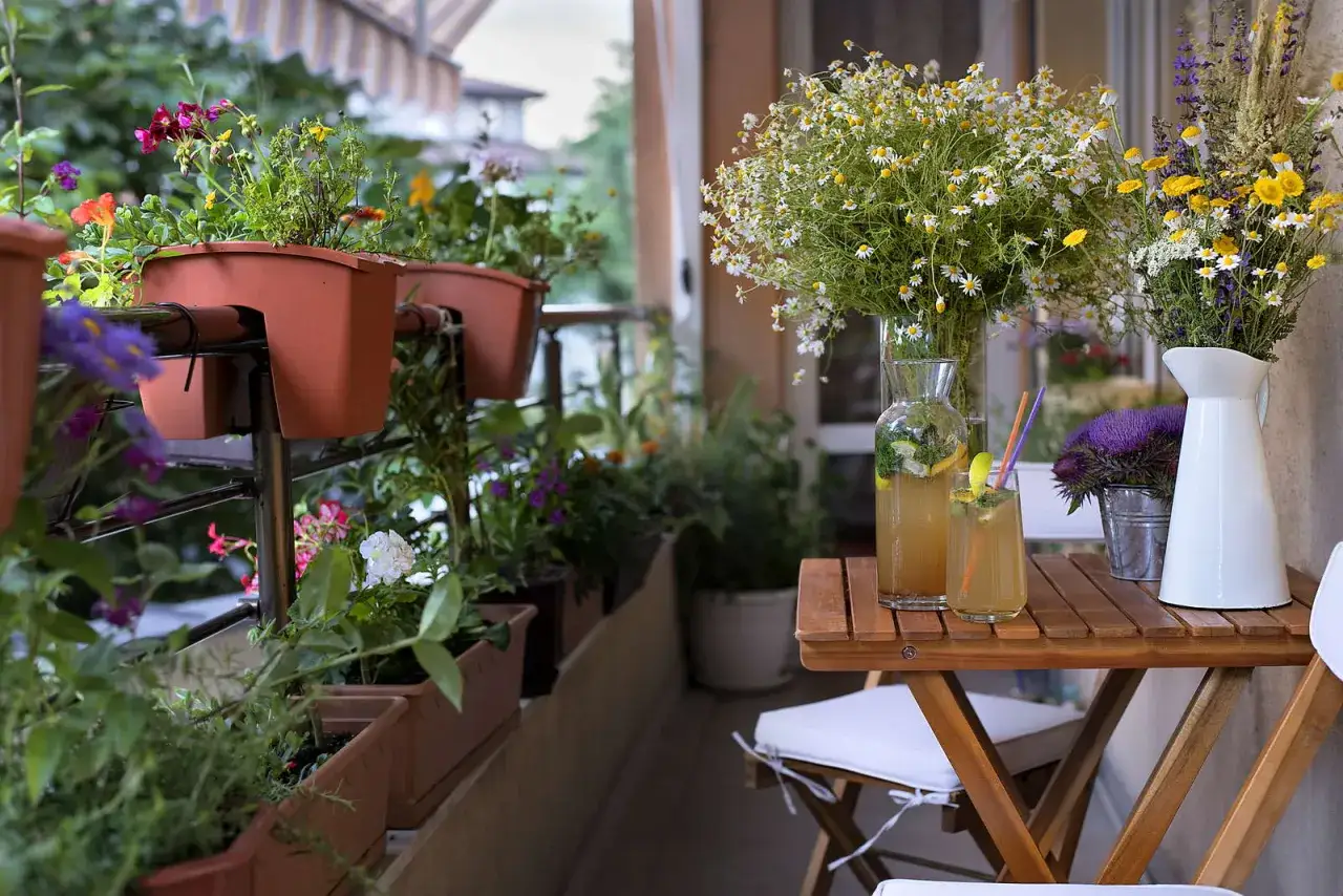 Balkon mit bunten Blumen in braunen K&auml;sten. Welche Balkonpflanzen sind bienenfreundlich? Hier bl&uuml;hen Margeriten und Kr&auml;uter.