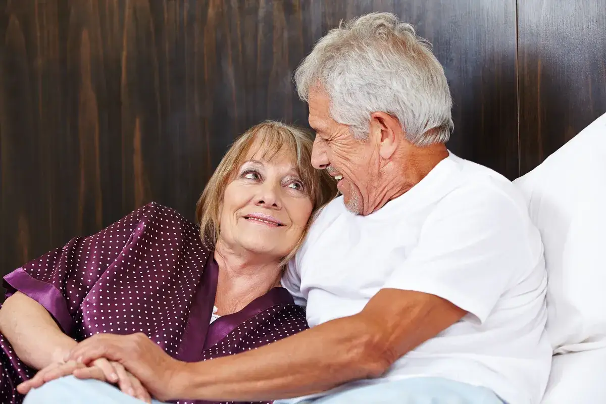 Couple âgé se tenant la main, souriant. Une image qui peut évoquer la perte de libido chez l'homme de 60 ans, mais aussi l'amour durable.
