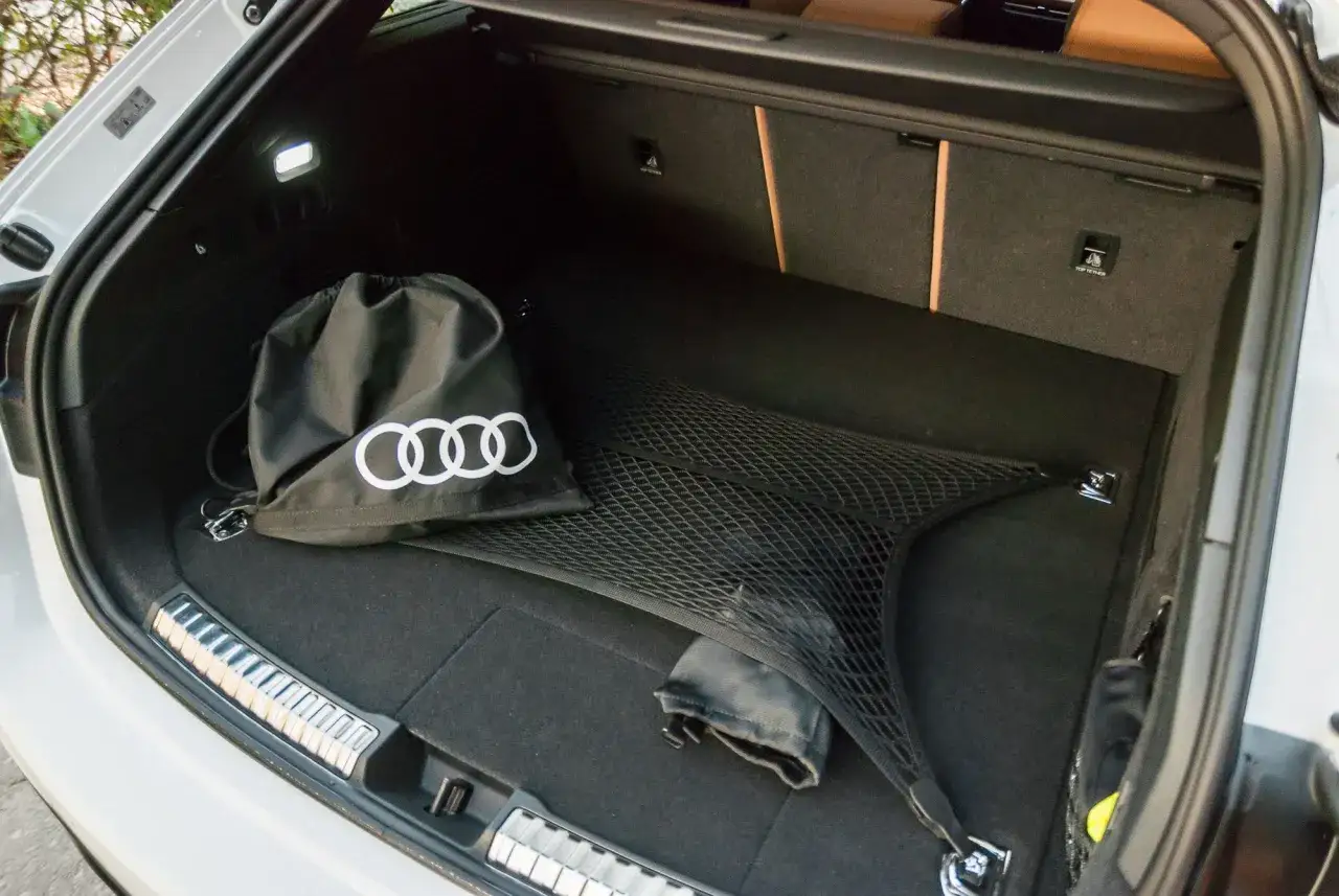 Bagażnik Audi A5 Avant 2025 z torbą z logo Audi i siatką do mocowania bagażu.