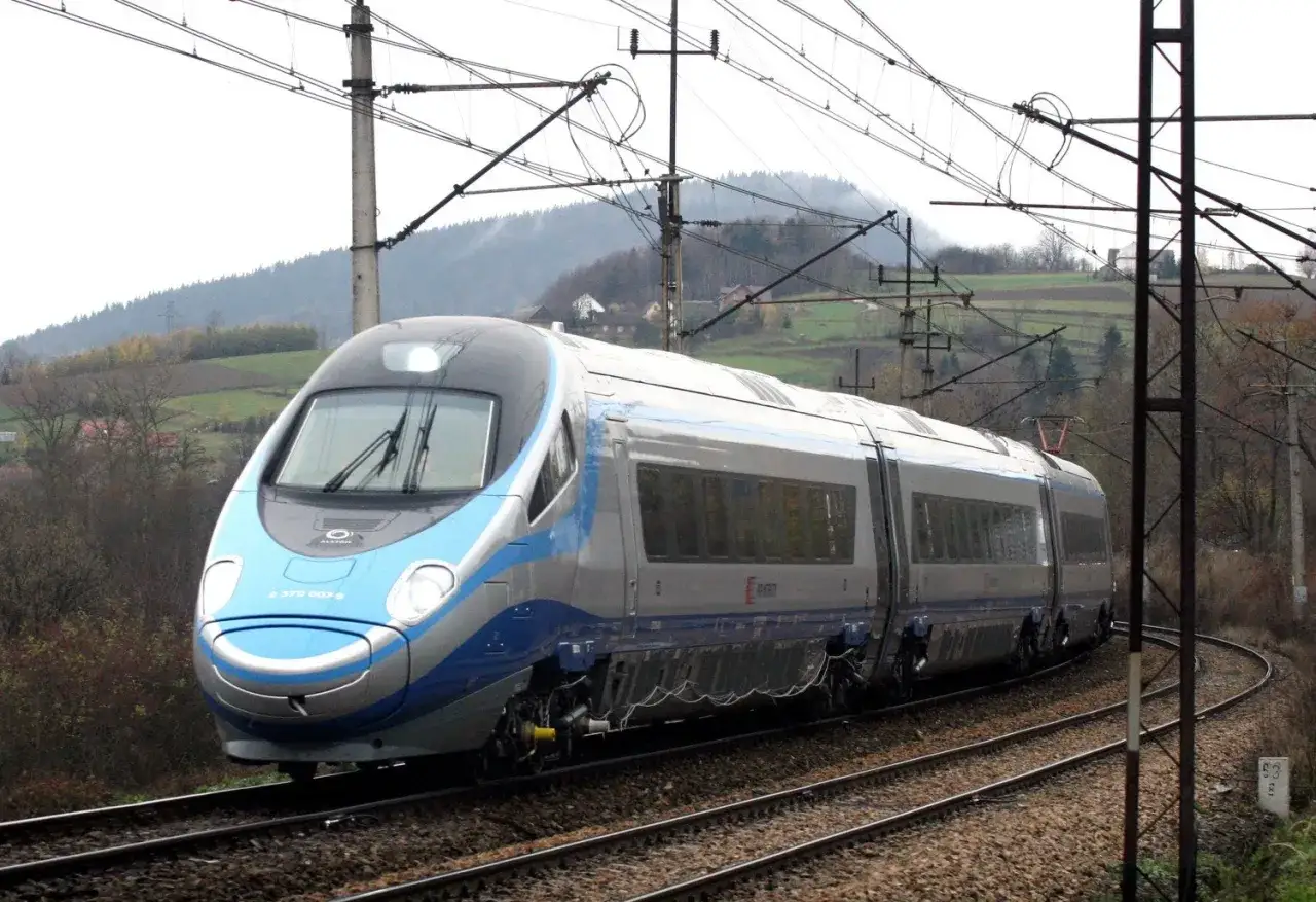 Pendolino Wrocław Warszawa pędzi po torach wśród jesiennych krajobrazów.
