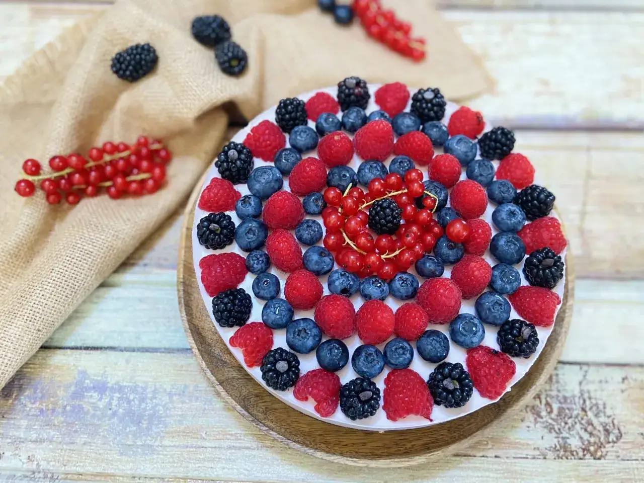 Cheesecake senza gelatina, decorata con lamponi, mirtilli, more e ribes rosso. Un tripudio di frutti di bosco su una base cremosa.