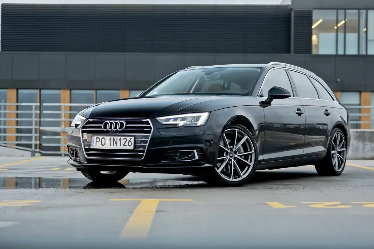 Czarne Audi A4 Avant na parkingu. Zwróć uwagę na jego eleganckie linie i sportowe felgi. Idealne audi a4 wymiary dla rodziny.
