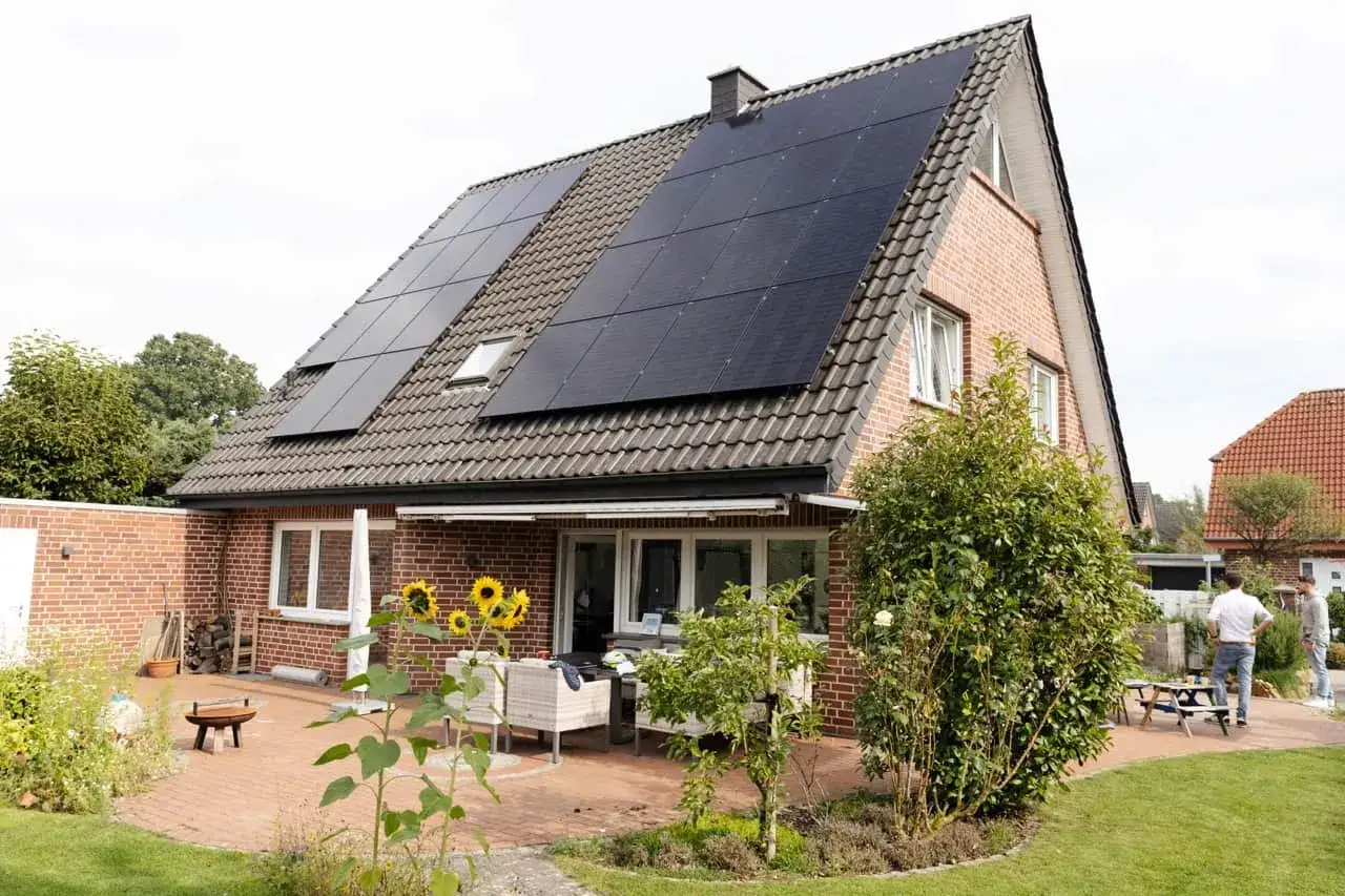 Zweist&ouml;ckiges Haus mit Solaranlage auf dem Dach. Die kwp bedeutung liegt in der nachhaltigen Energieerzeugung f&uuml;r das Zuhause.