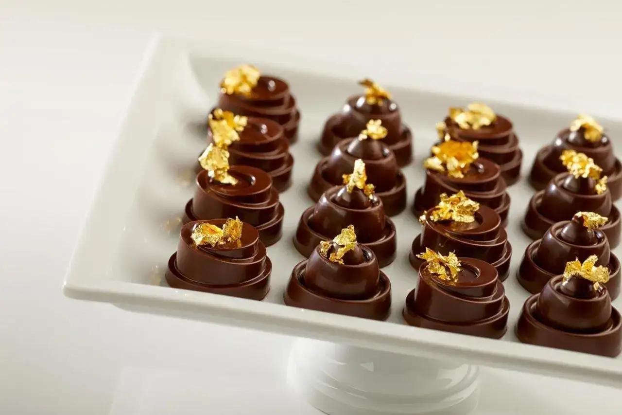 Douze chocolats somptueux, ornés de feuilles d'or, composent cette composition alimentaire d'exception.