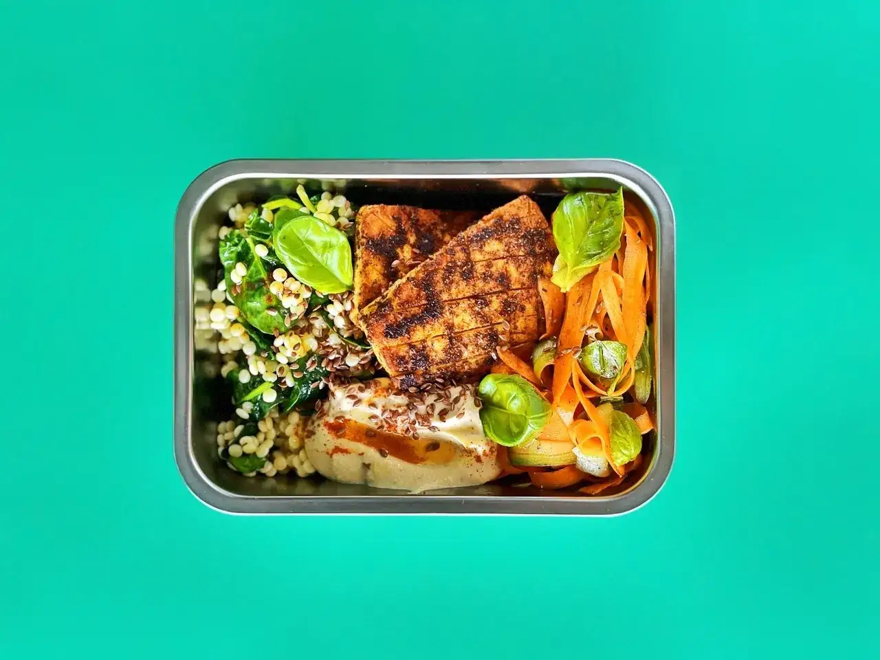 Pyszna dieta pudełkowa wegańska Warszawa: grillowany tofu, kasza, szpinak, marchewka i hummus.