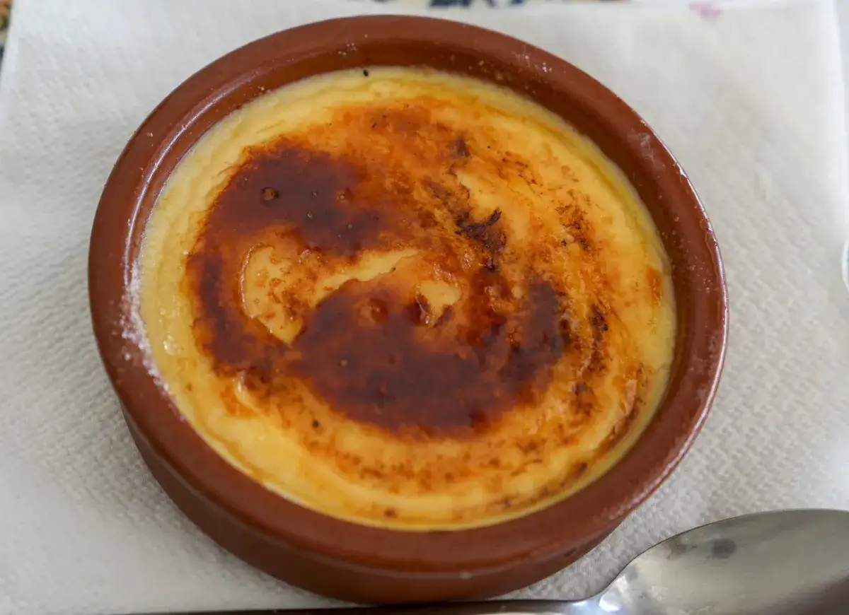 Pyszna crema catalana w glinianej miseczce, z chrupiącą, karmelizowaną skórką.