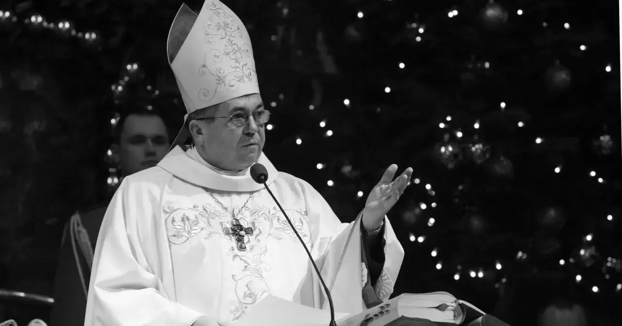 Biskup w stroju liturgicznym, z mitrą na głowie, przemawia przy mikrofonie. Czy biskup to zawód? To powołanie i służba.