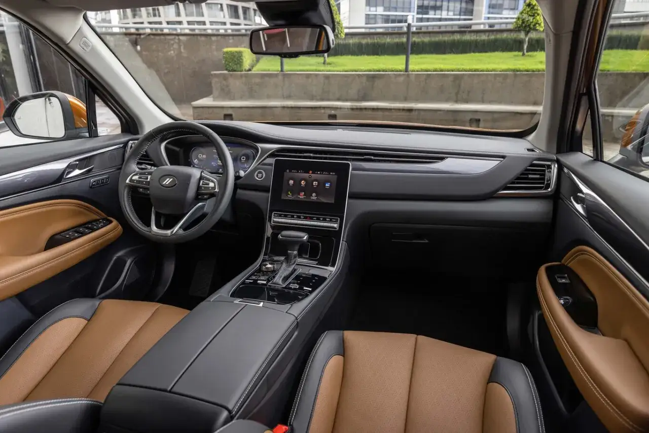Wnętrze Dodge Journey 3.6 z brązową tapicerką i nowoczesnym panelem multimedialnym.