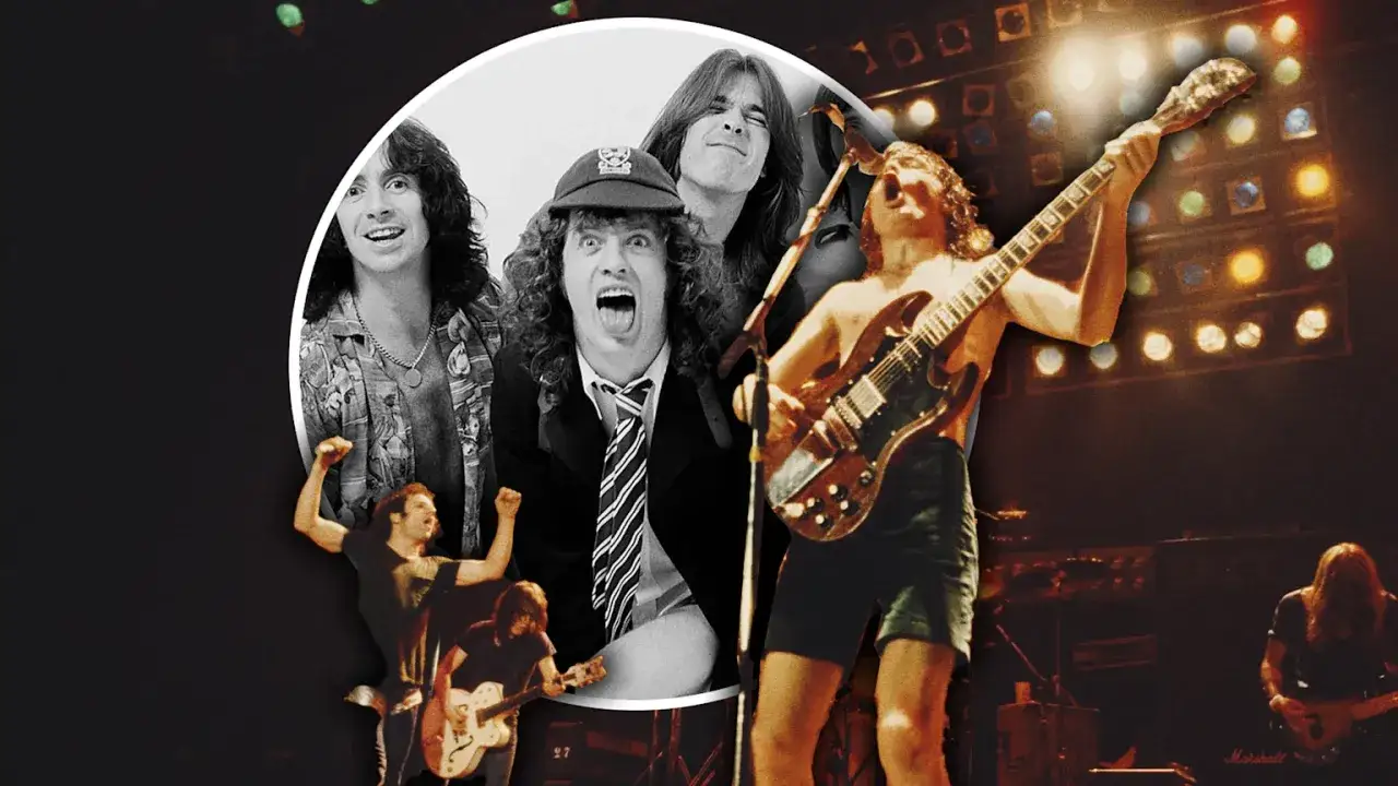 Gitarzysta AC DC w akcji, z innymi członkami zespołu w tle. Energia rock and rolla!