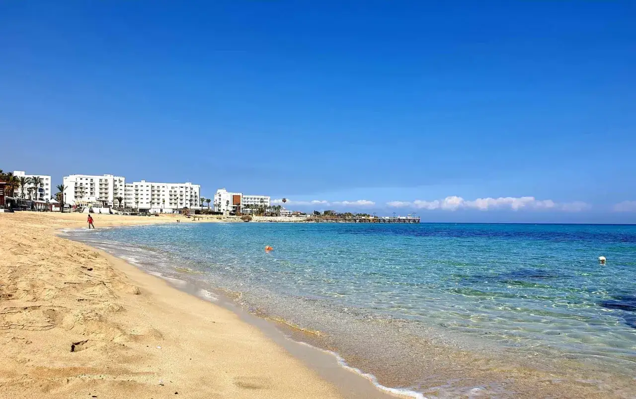Piękna plaża w Protaras na Cyprze. Czysta, turkusowa woda, złoty piasek i białe hotele tworzą idealne wakacyjne tło.