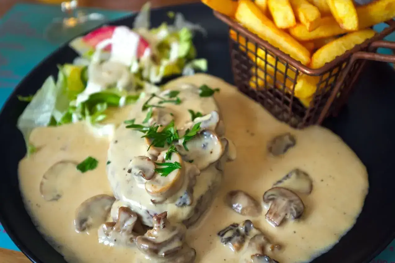 Delicioso blanquette de ternera con champi&ntilde;ones, acompa&ntilde;ado de patatas fritas y ensalada.