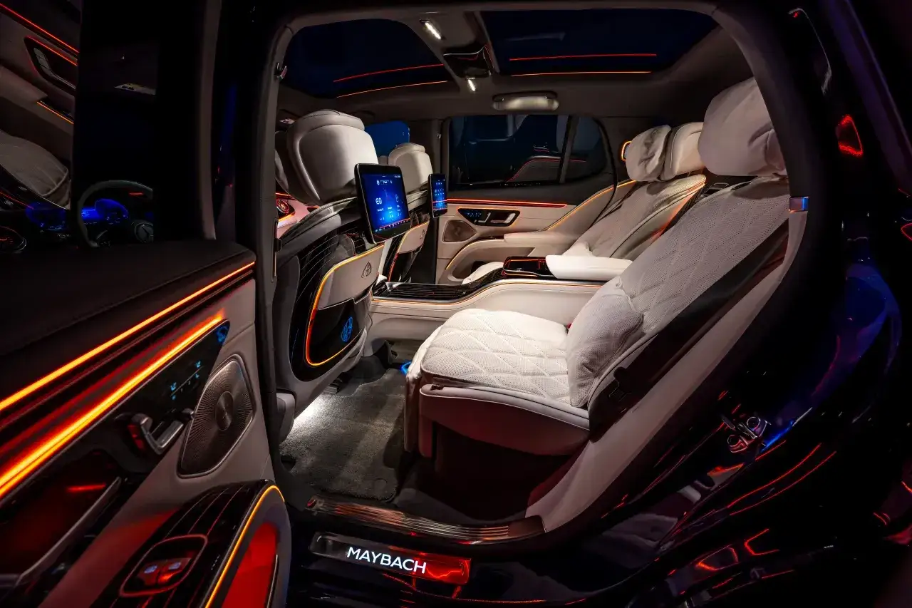 Luksusowe wnętrze Maybach S680 z podświetlanymi detalami i ekranami dla pasażerów.
