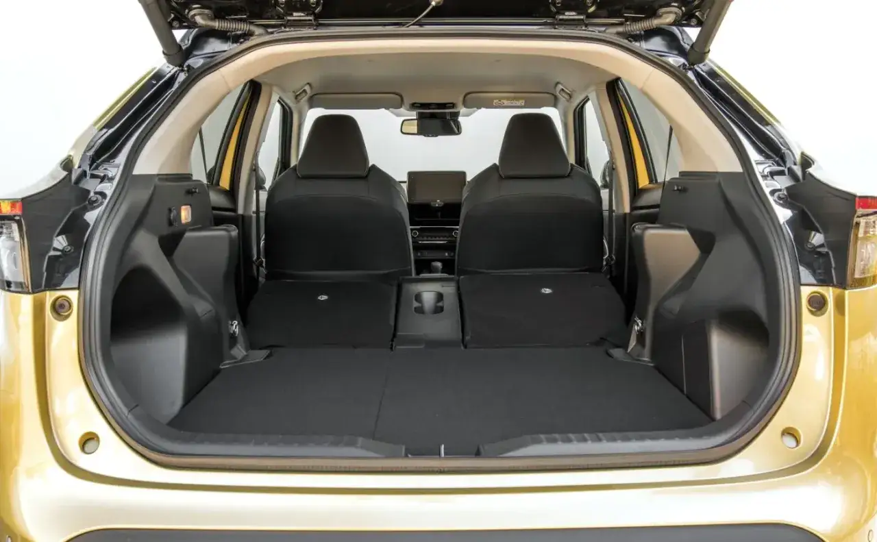 Przestronny bagażnik Toyoty Yaris Cross Hybrid z opuszczonymi tylnymi siedzeniami, gotowy na podróż.