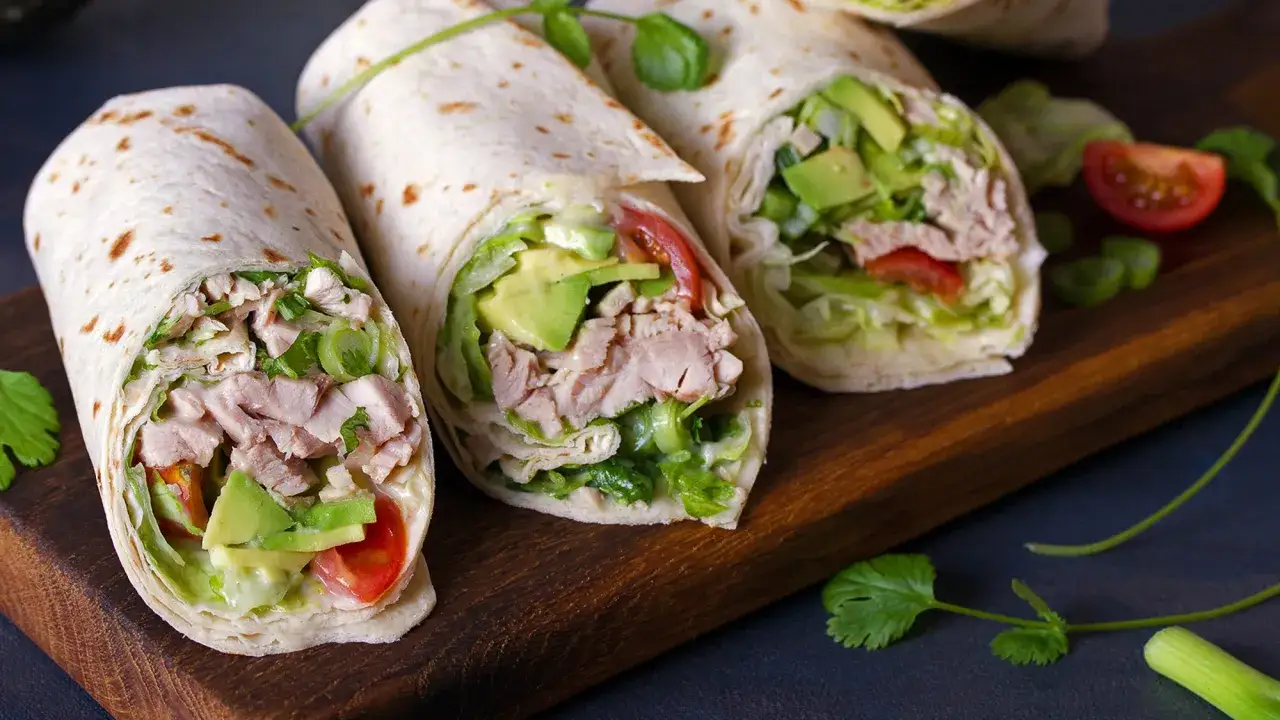 Trois wraps au poulet, avocat et tomate, prêts à être dégustés. Une recette wrap poulet facile et savoureuse.